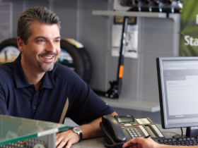 Vue d'un homme assis à un bureau, en interaction avec un spécialiste Acura.