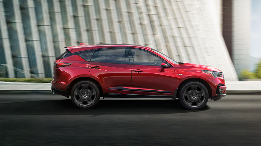 Red Acura RDX A-Spec drives through the city. / Acura RDX A-Spec rouge roulant en ville.